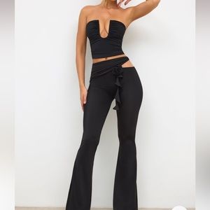 Mid-rise black trousers with a strapless plunge neck top